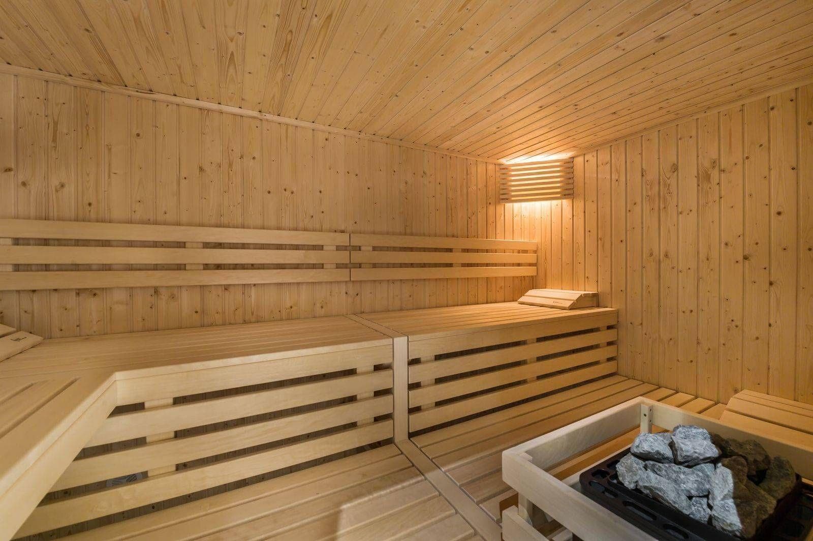 Private cedar sauna with tiered seating and electric rock heater