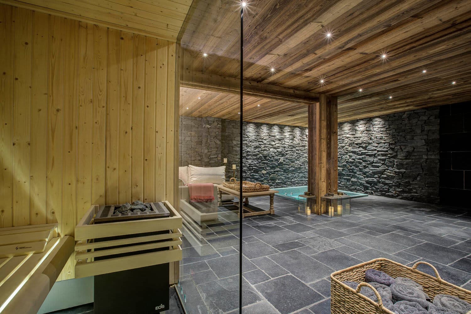 Spa area with glass-walled sauna, heated pool, and stone accents