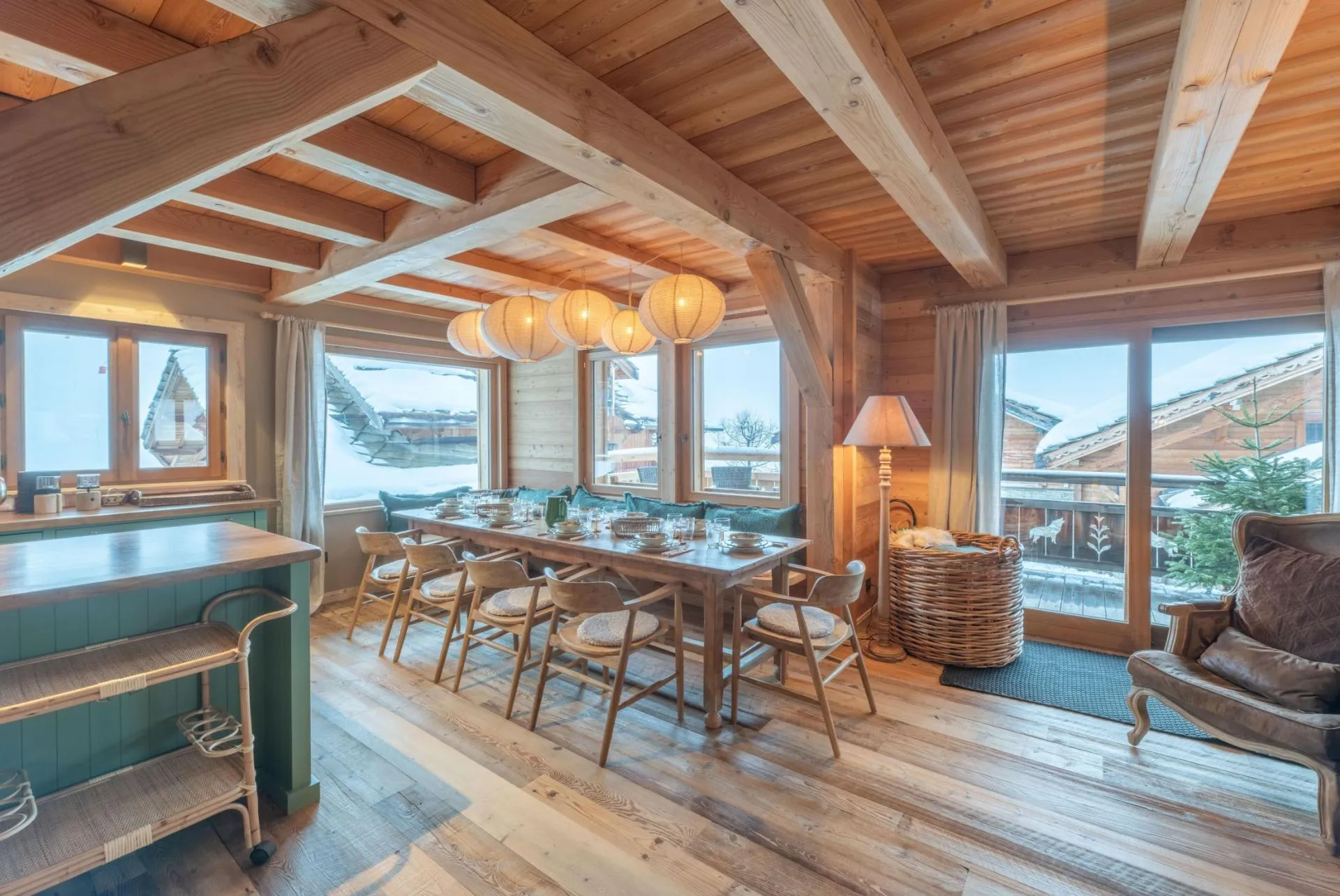 Dining area beneath exposed timber beams with mountain views