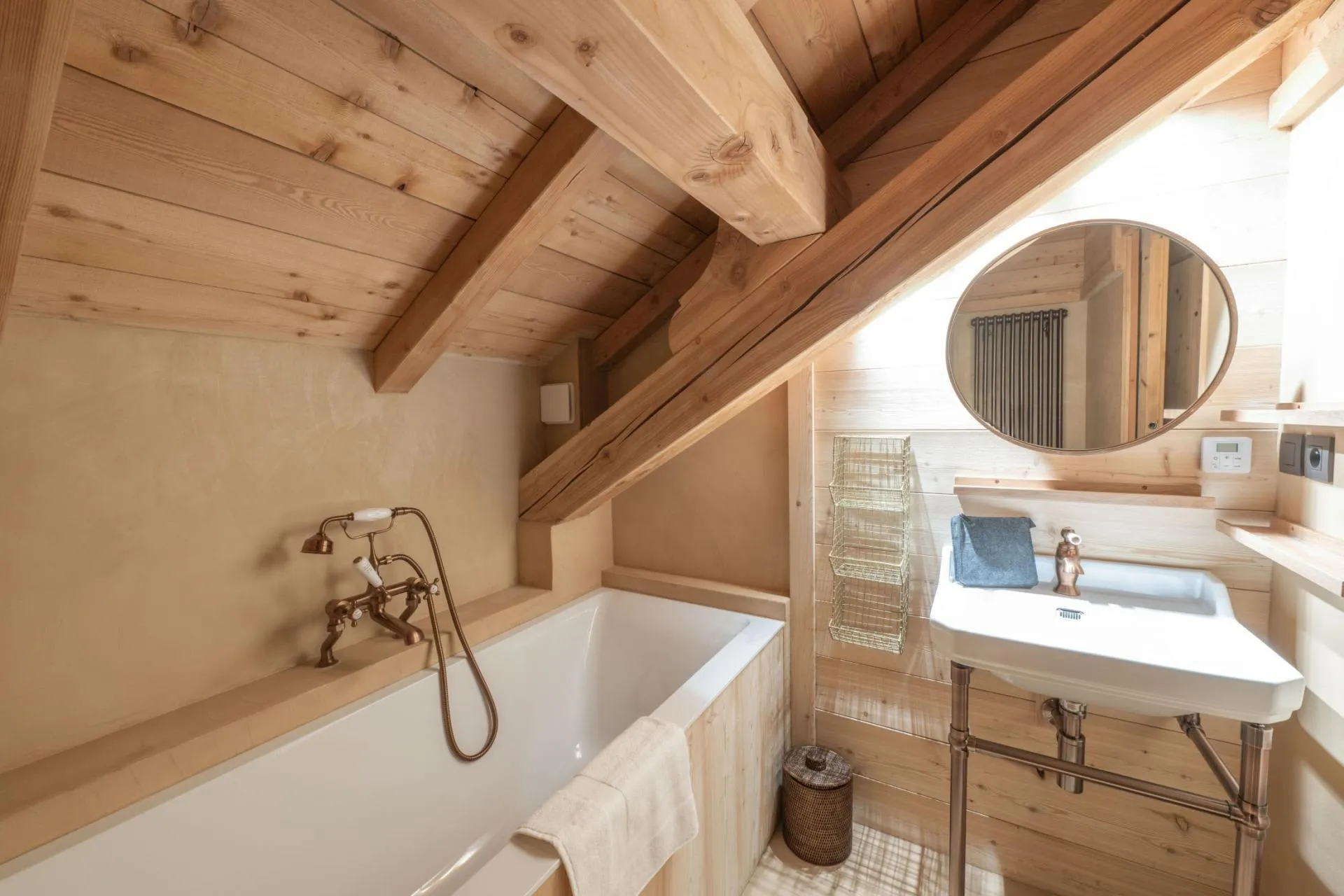 Bathroom with a bathtub beneath a timber-lined ceiling