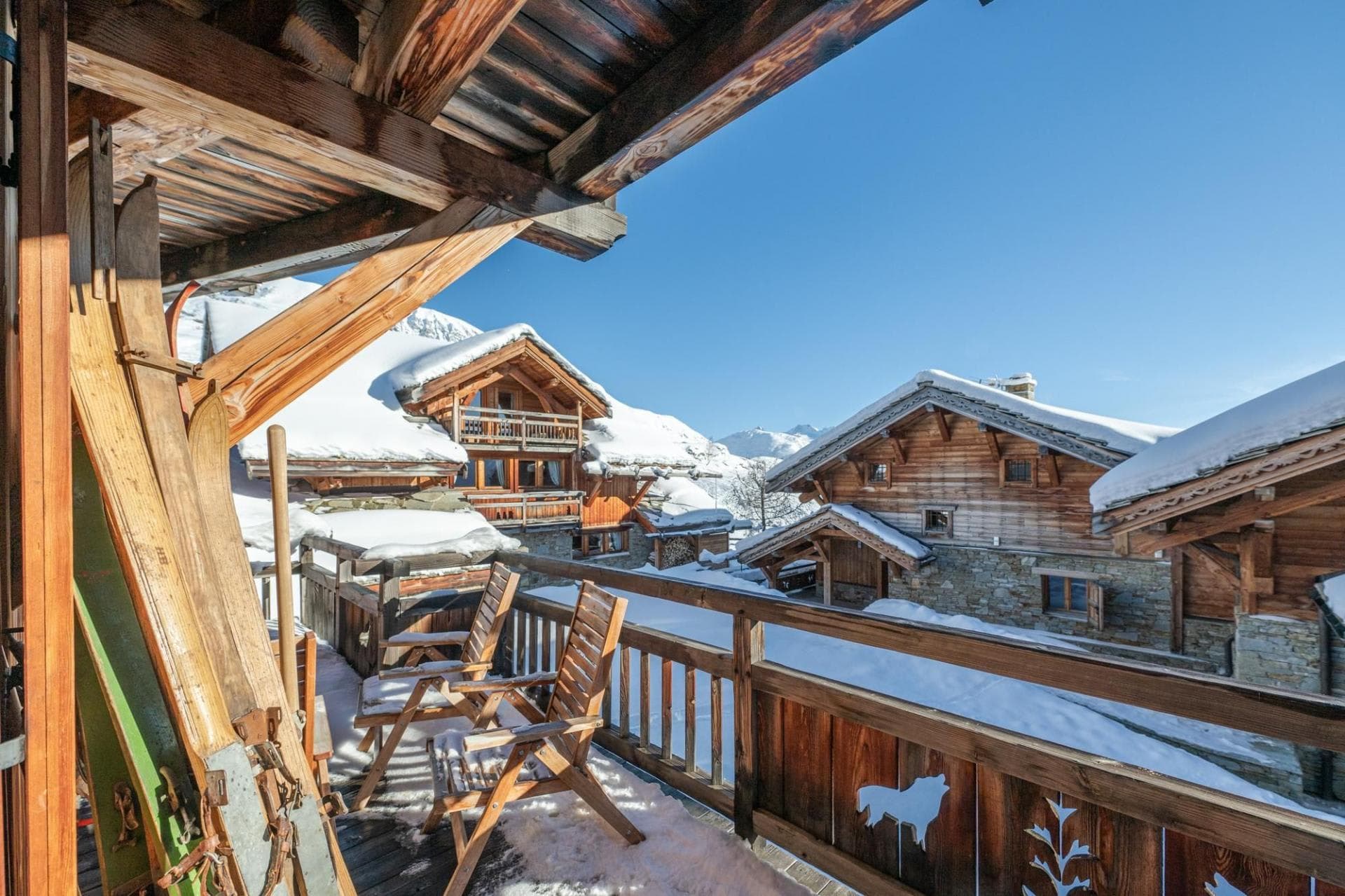 Covered balcony with vintage wooden skis and mountain village views