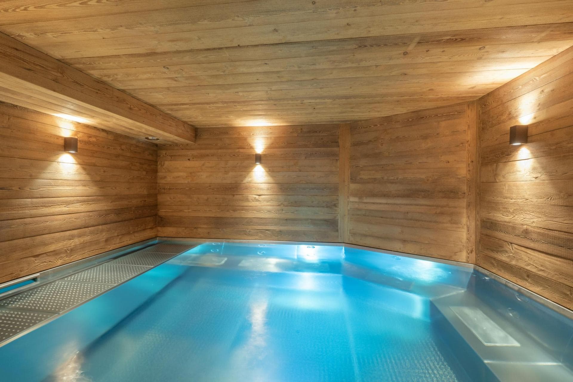 Indoor pool with wood-paneled walls and built-in bench seating