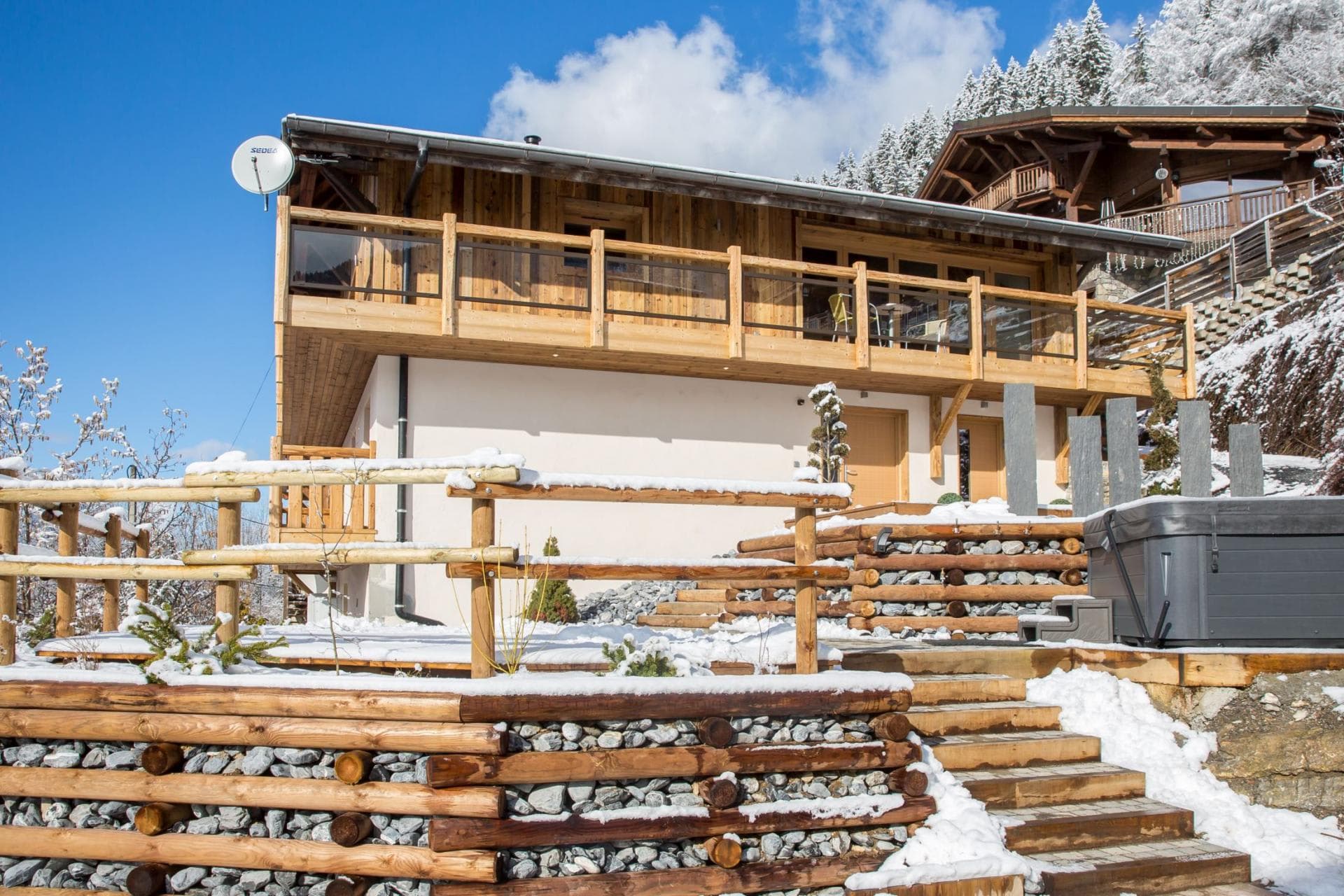 Chalet exterior with upper-level balcony and private hot tub