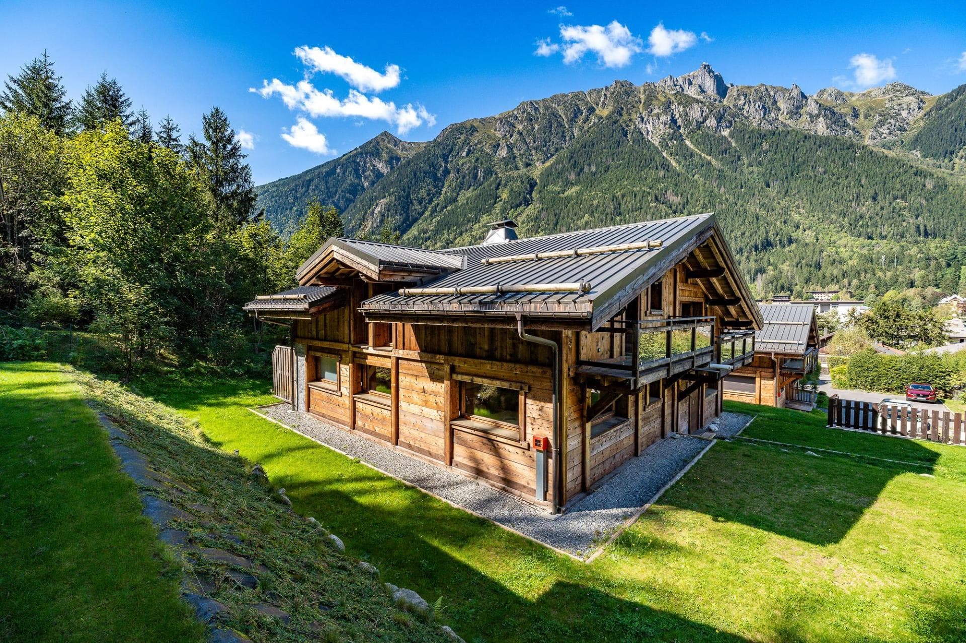 Timber chalet exterior with private lawn and Aiguilles Rouges mountain views