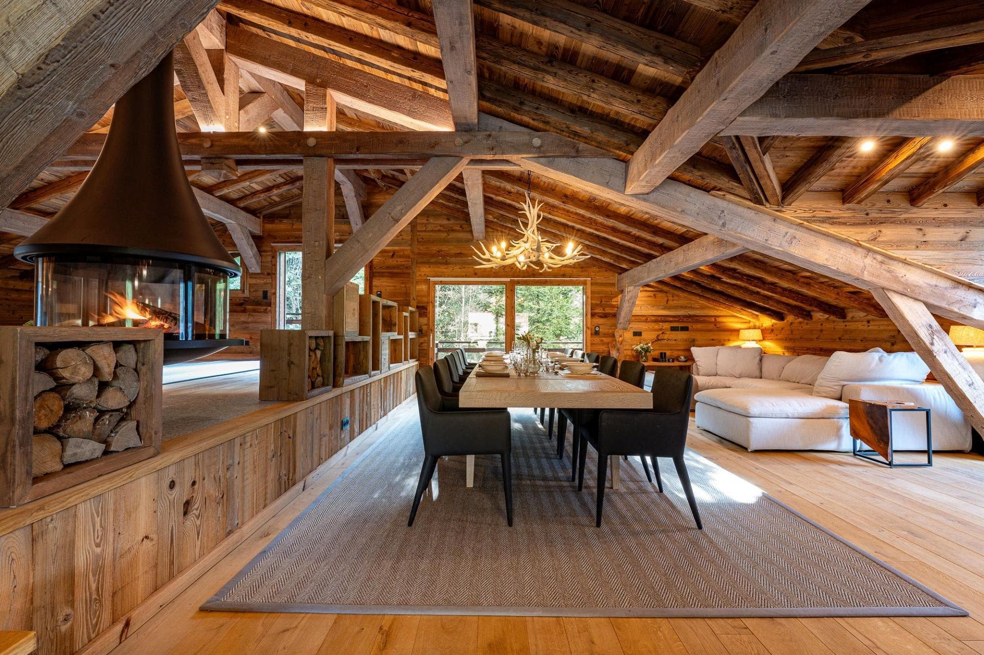 Open-plan dining area seats 10 near suspended fireplace and lounge