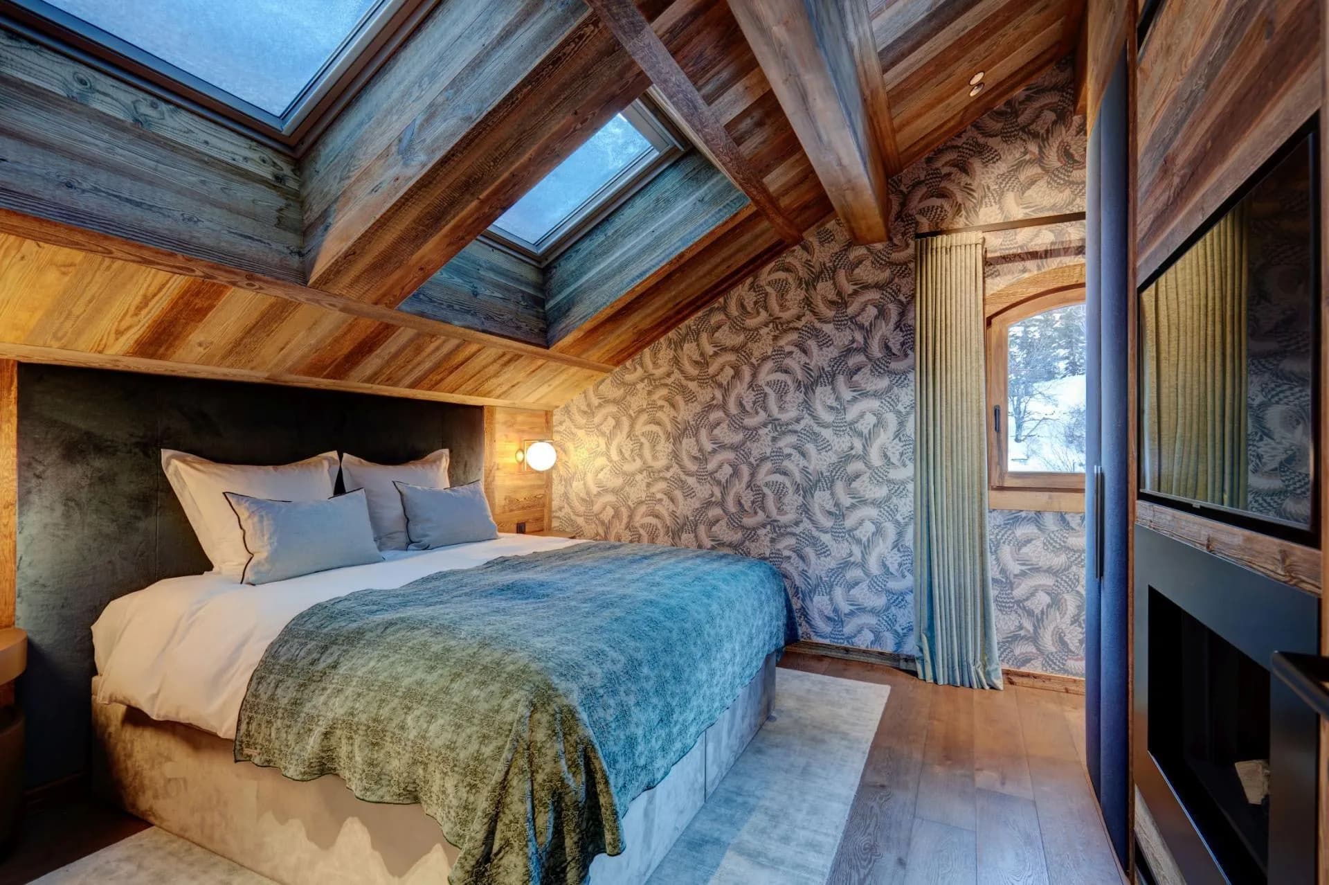 Double bedroom with blue bedding and skylight