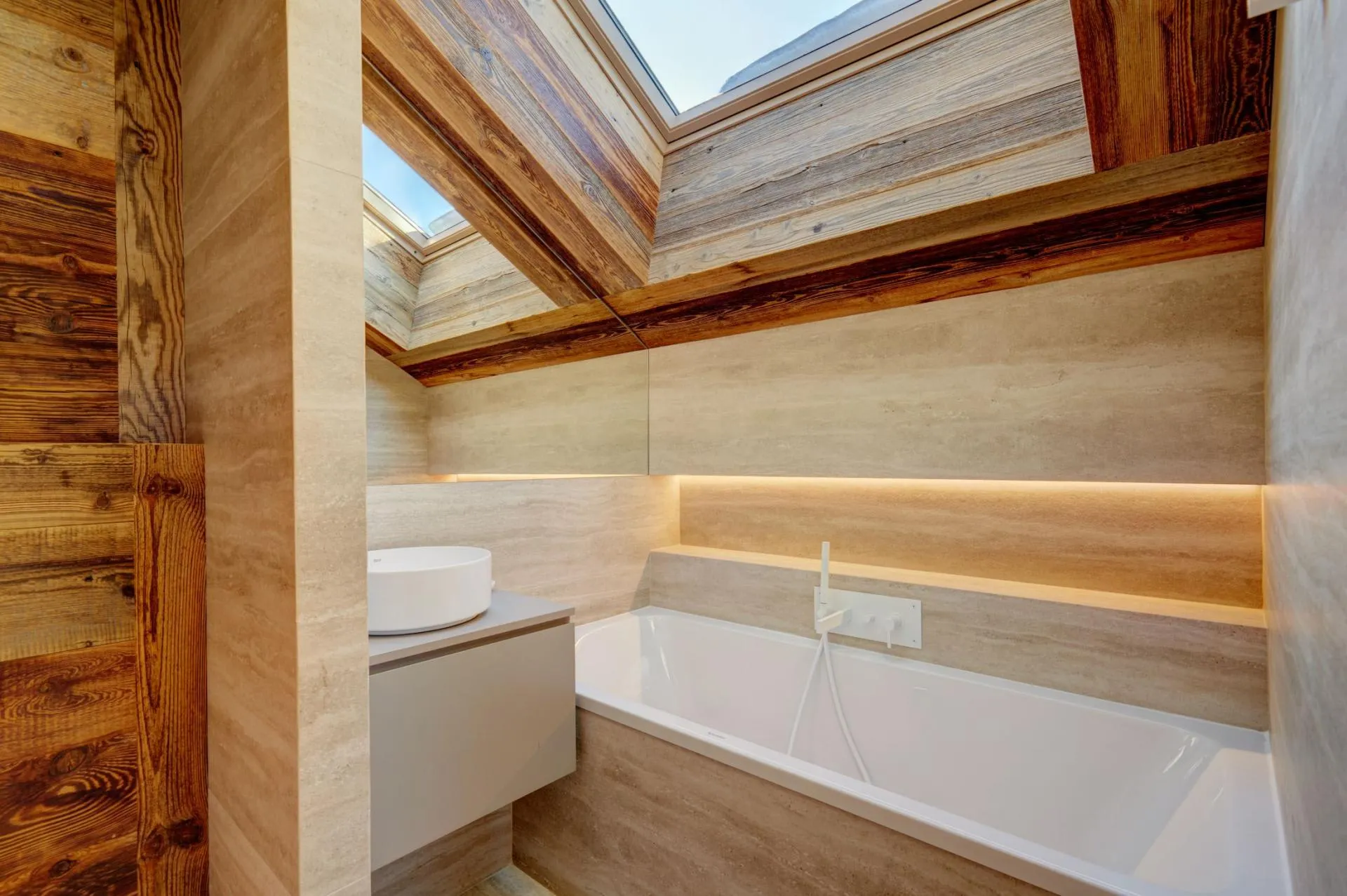 Bathroom with bathtub and basin beneath a skylight