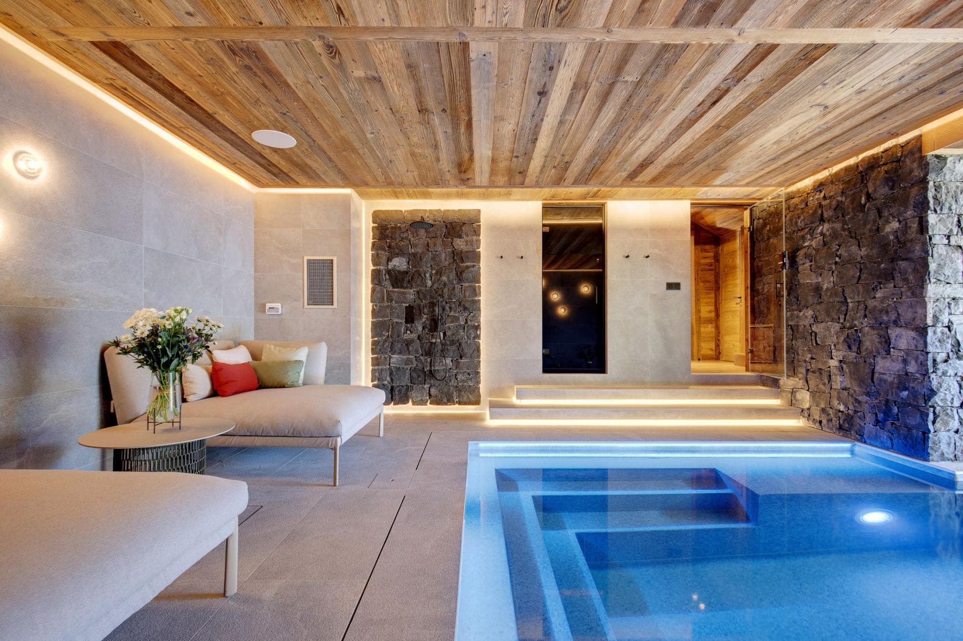 Indoor spa with heated pool and stone-walled walk-in shower