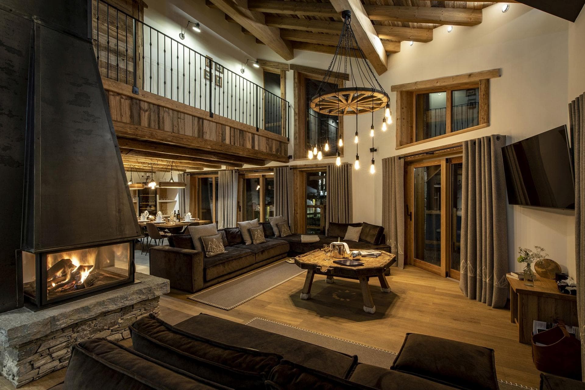 Double-height living room with wood-burning fireplace and mezzanine balcony