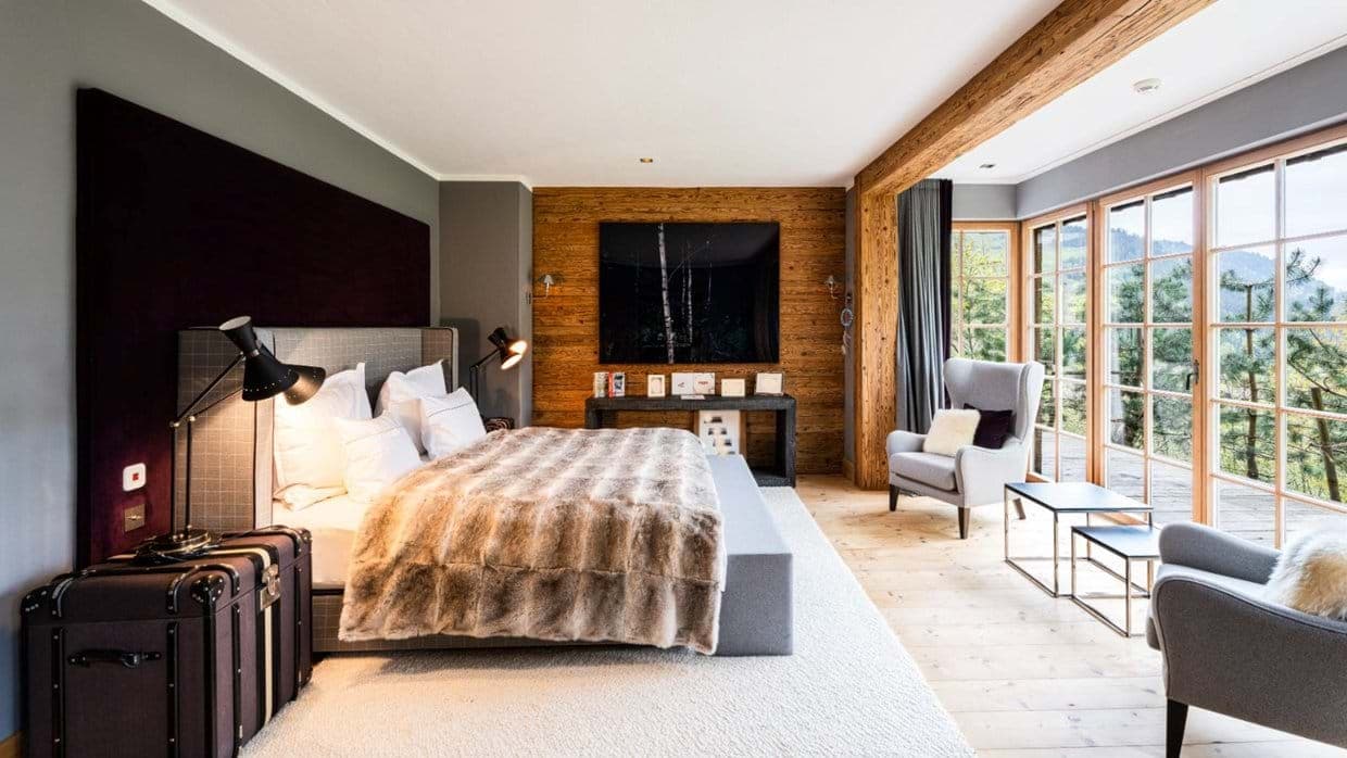 Primary bedroom with king bed and floor-to-ceiling forest views