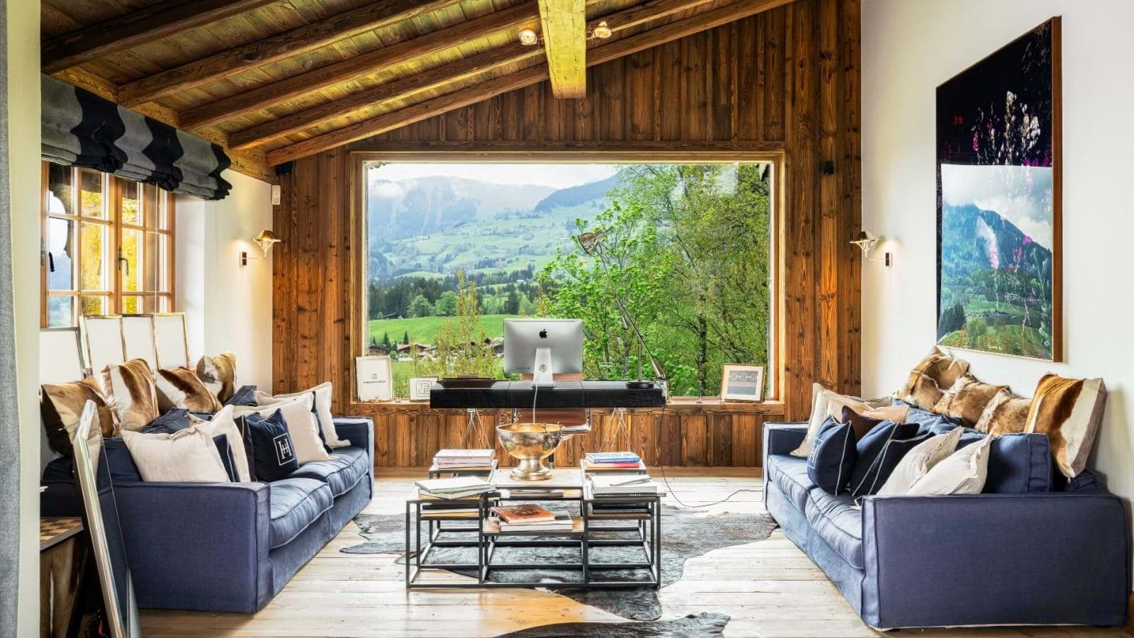 Wood-paneled lounge with dedicated workspace and mountain views