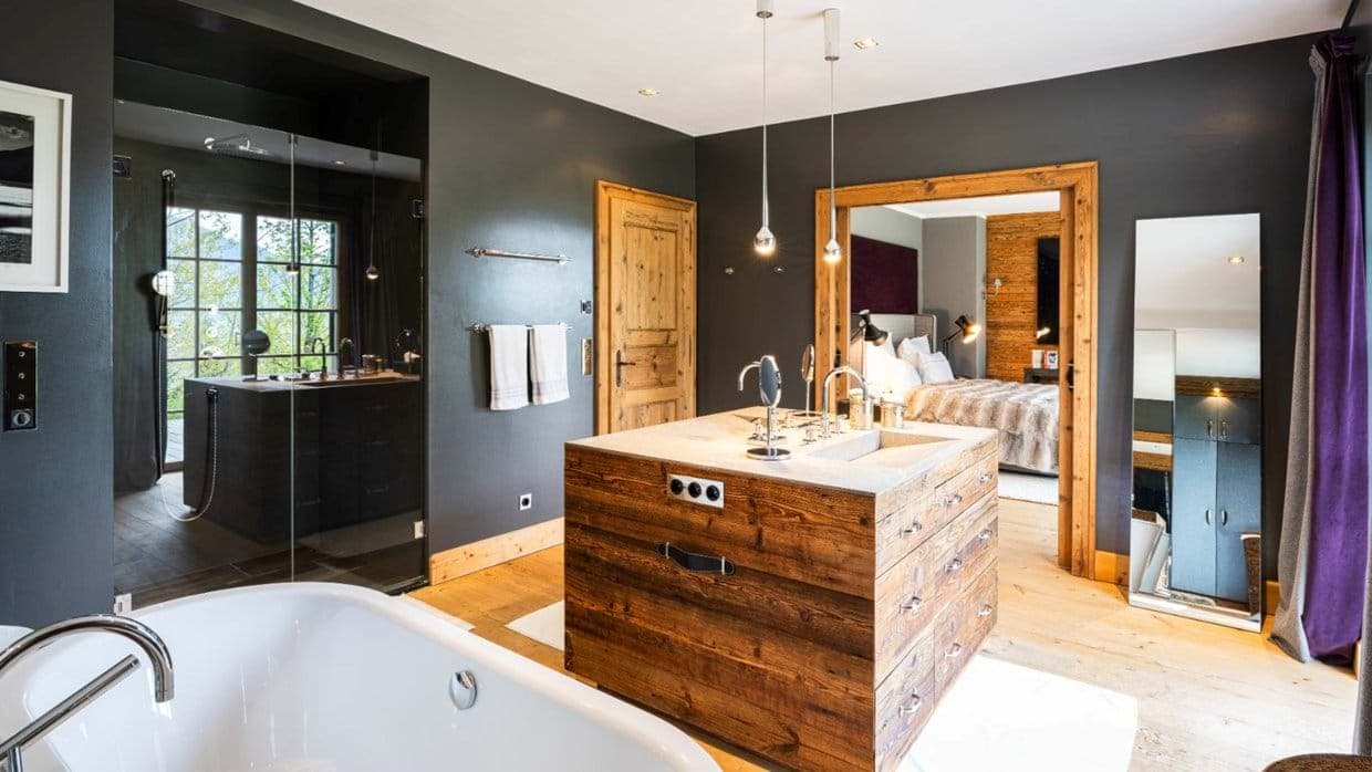 Ensuite bathroom with central wood island vanity and soaking tub