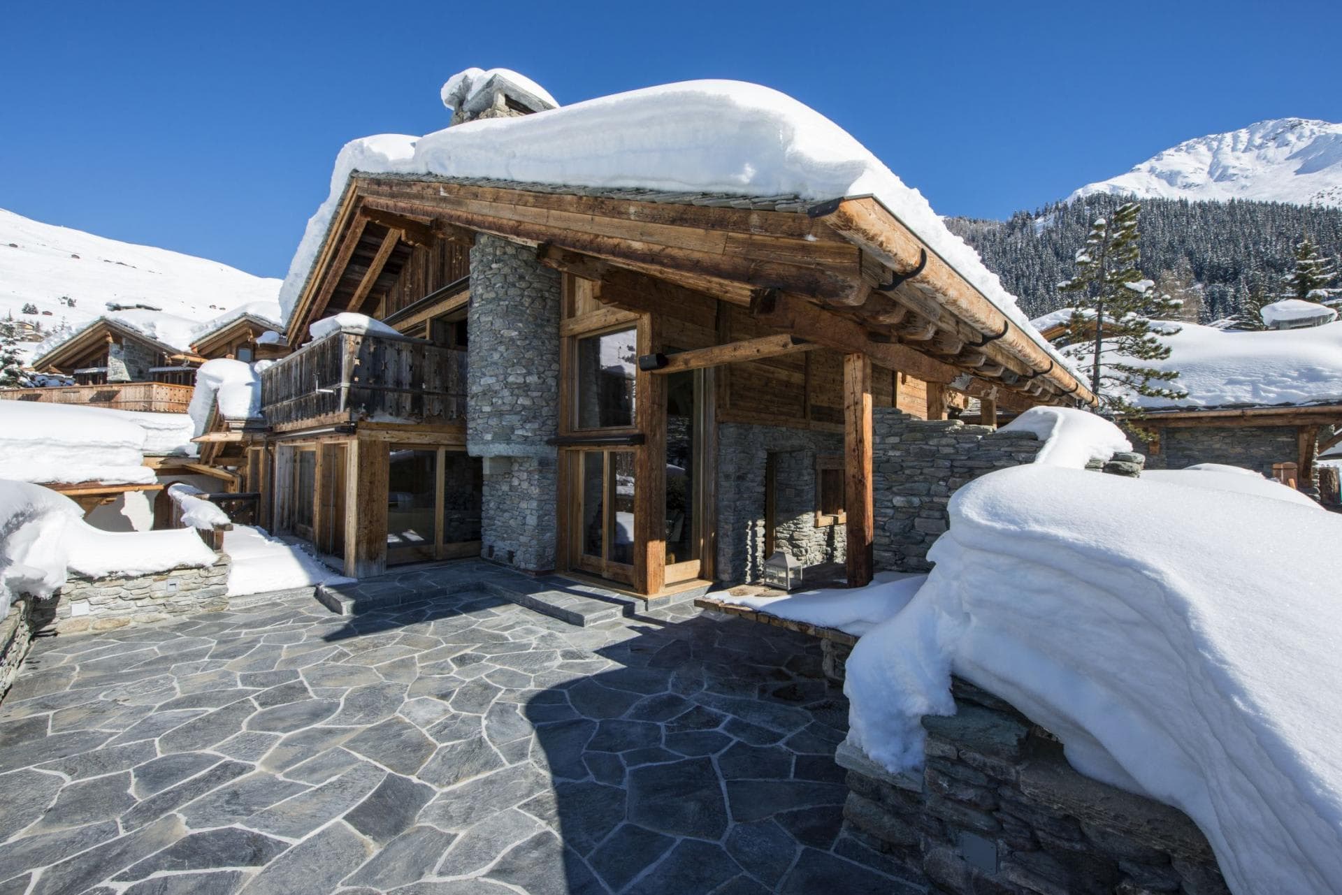 Stone-paved terrace with mountain views and direct chalet access