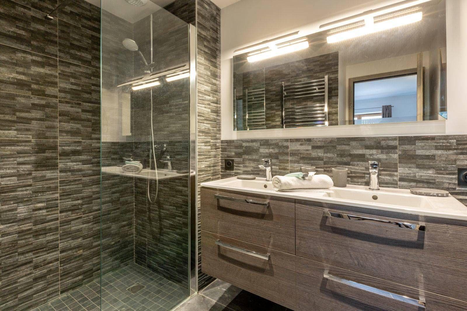 Dual vanity bathroom with walk-in glass shower and heated towel rail