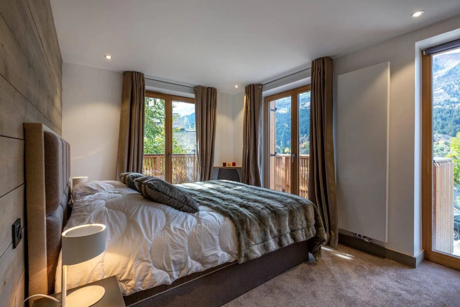 Bedroom with king bed and dual balcony access to mountain views