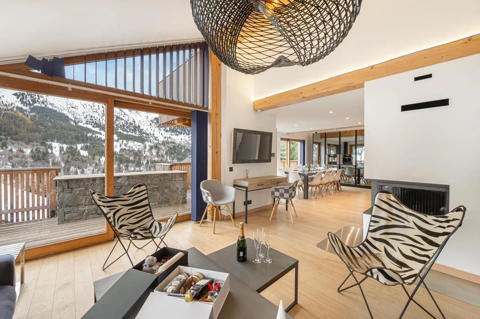 Living area with workspace and floor-to-ceiling mountain views