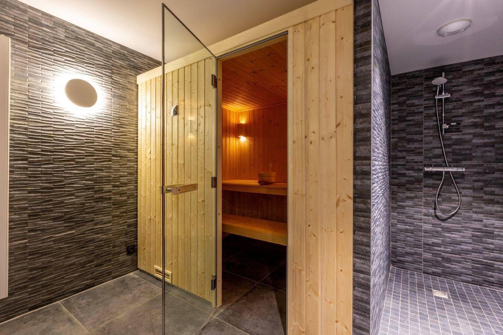 Private sauna with tiered seating and adjacent walk-in shower