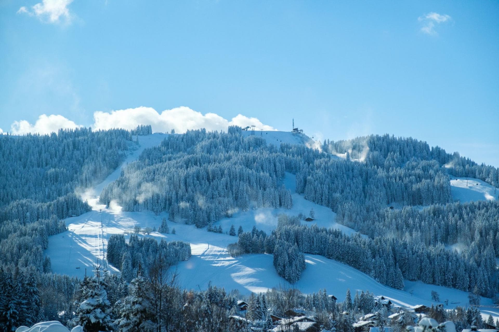 Ski resort view with groomed runs and active snowmaking