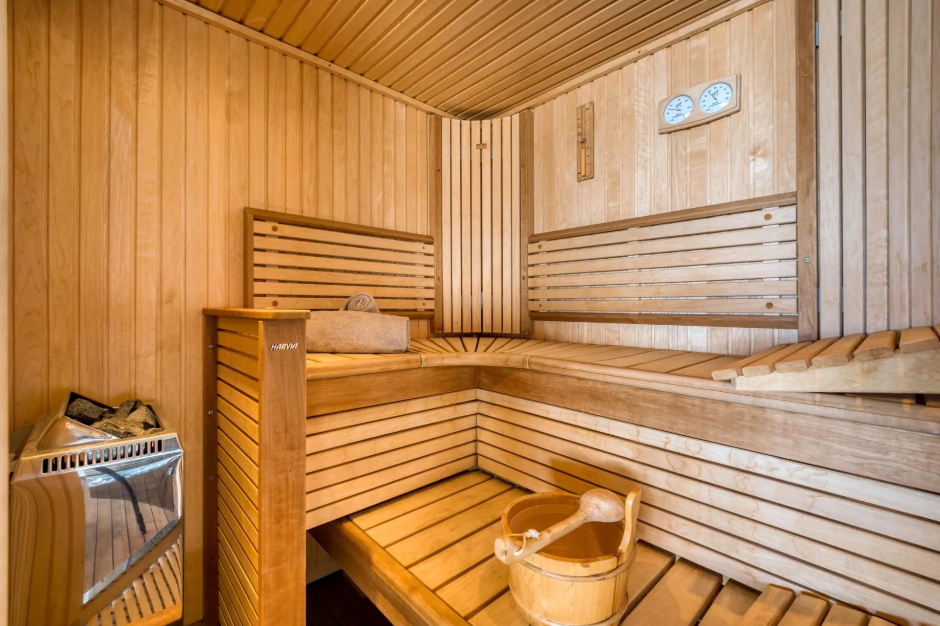 Private sauna with Harvia electric heater and multi-level bench seating