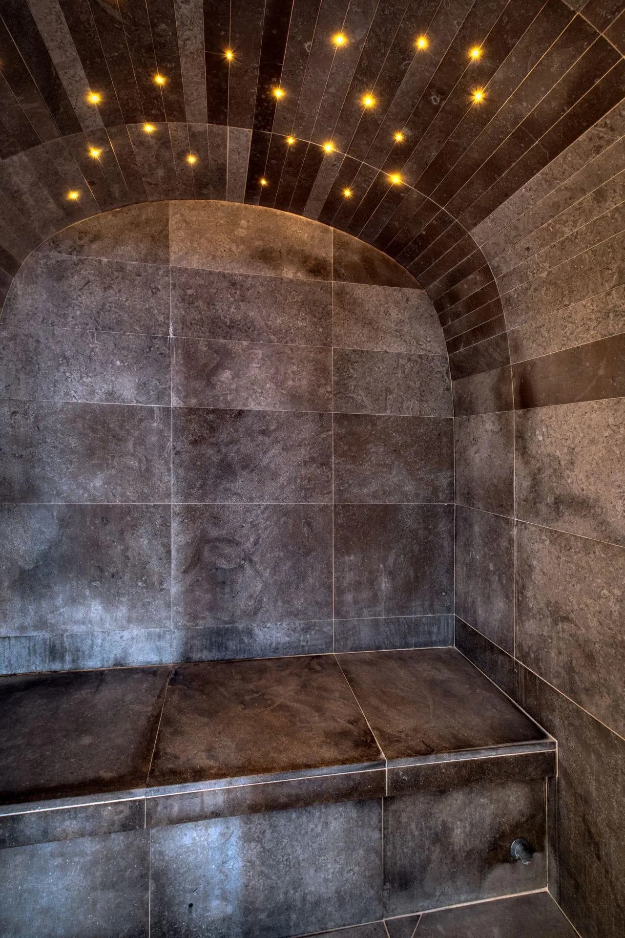 Stone steam room with vaulted ceiling and fiber optic lighting