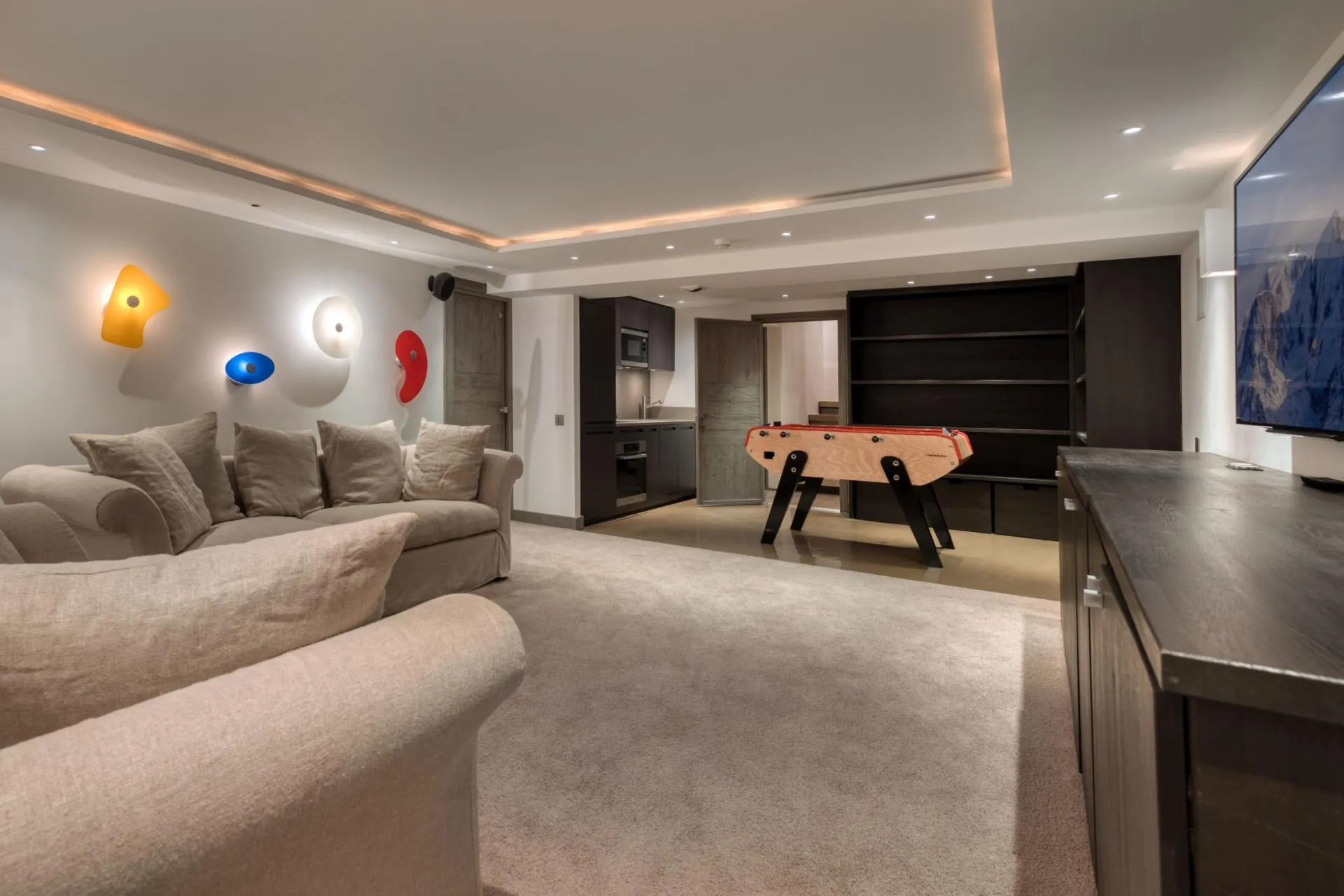 Media room with foosball table, kitchenette, and wall-mounted smart TV