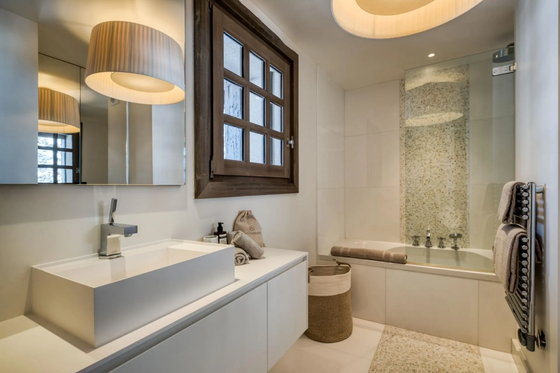 Bathroom with soaking tub, rainfall shower, and heated towel rack