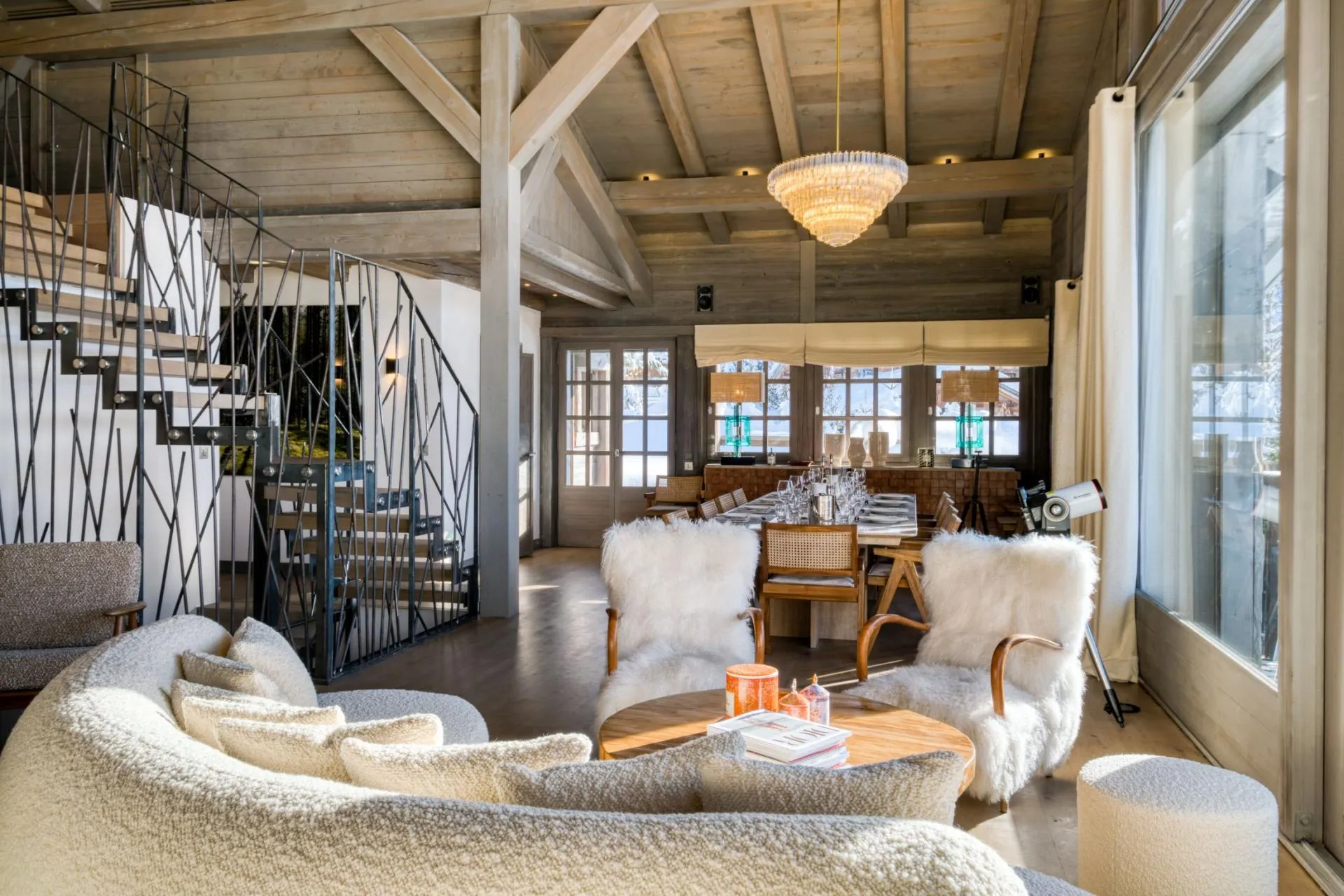 Open-concept living and dining area with vaulted timber ceilings and seating for 10