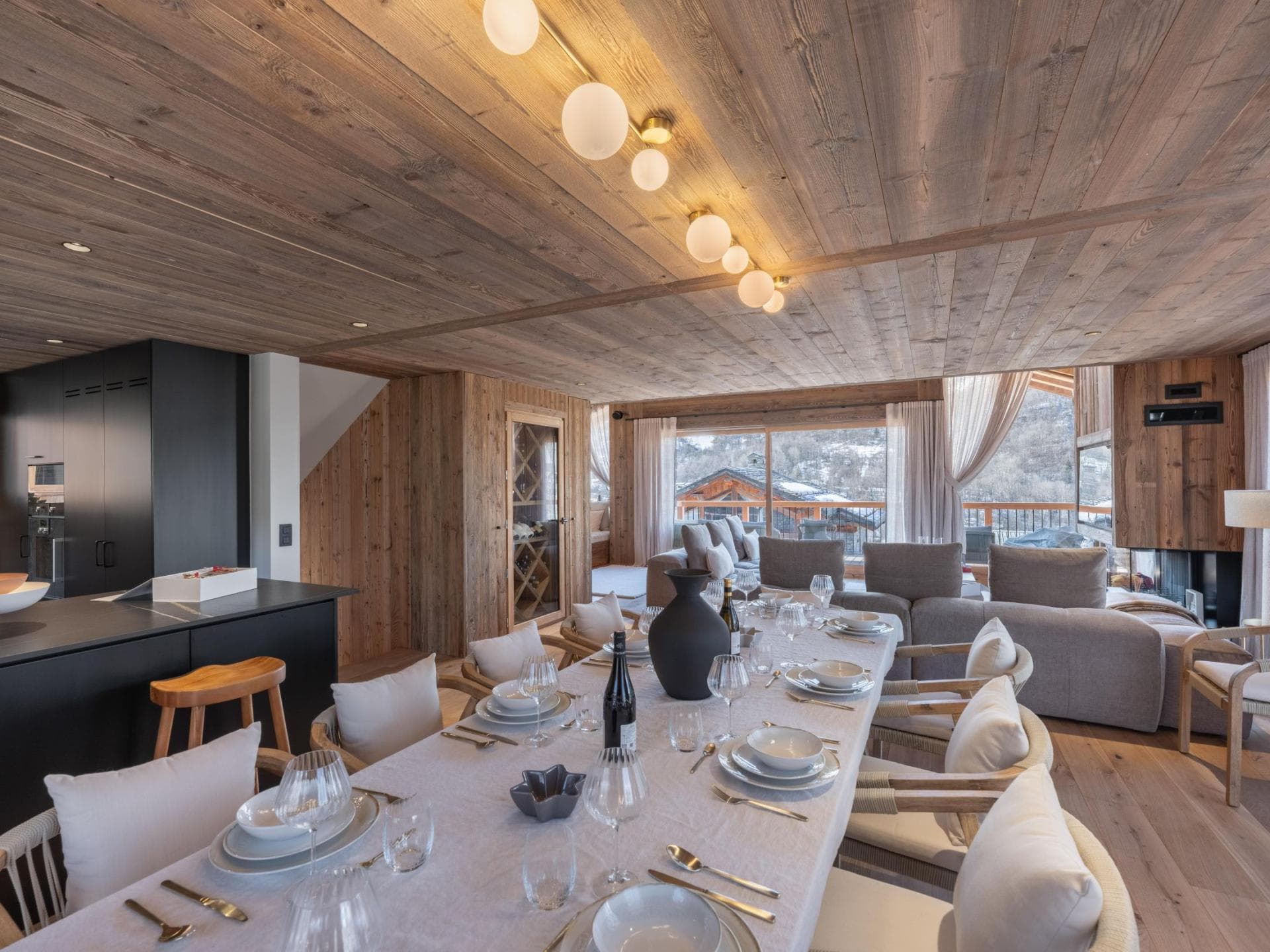 Open-plan dining area seating 10 with adjacent wine storage and mountain views