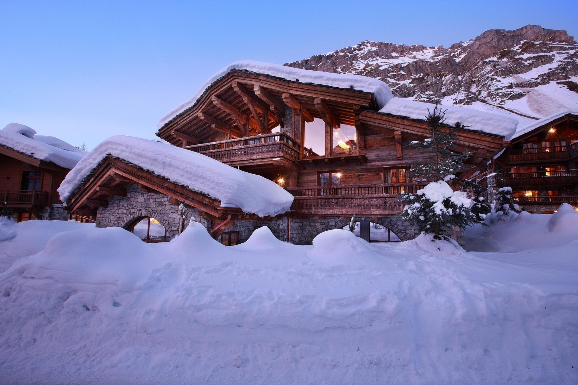 Ski-in, ski-out timber chalet with stone base and mountain backdrop