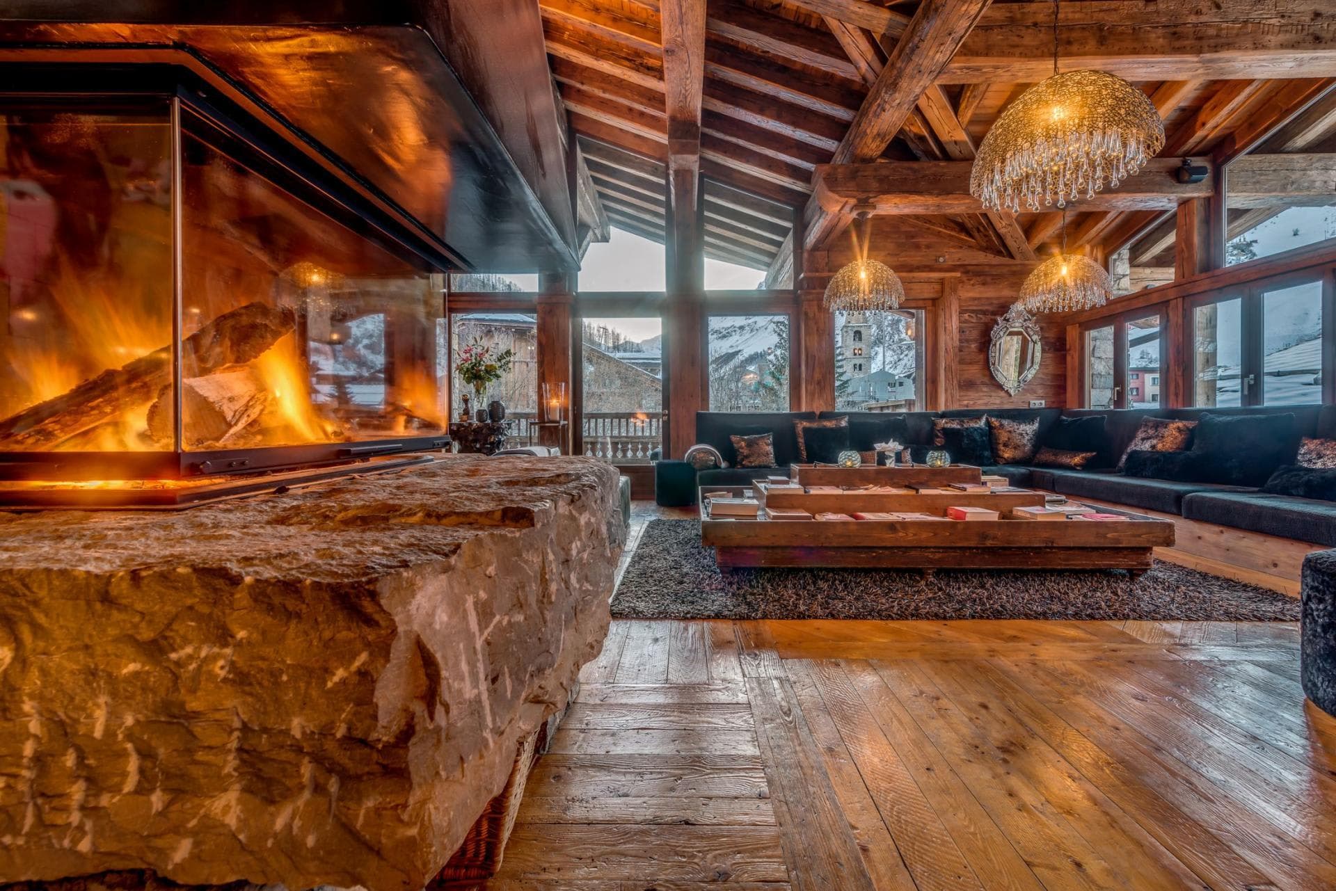 Living area with glass-enclosed stone fireplace and mountain views