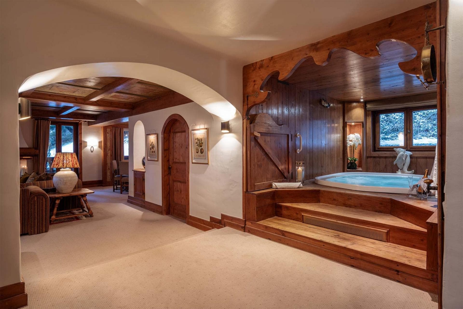 Indoor hot tub with wood paneling and views of snowy landscape