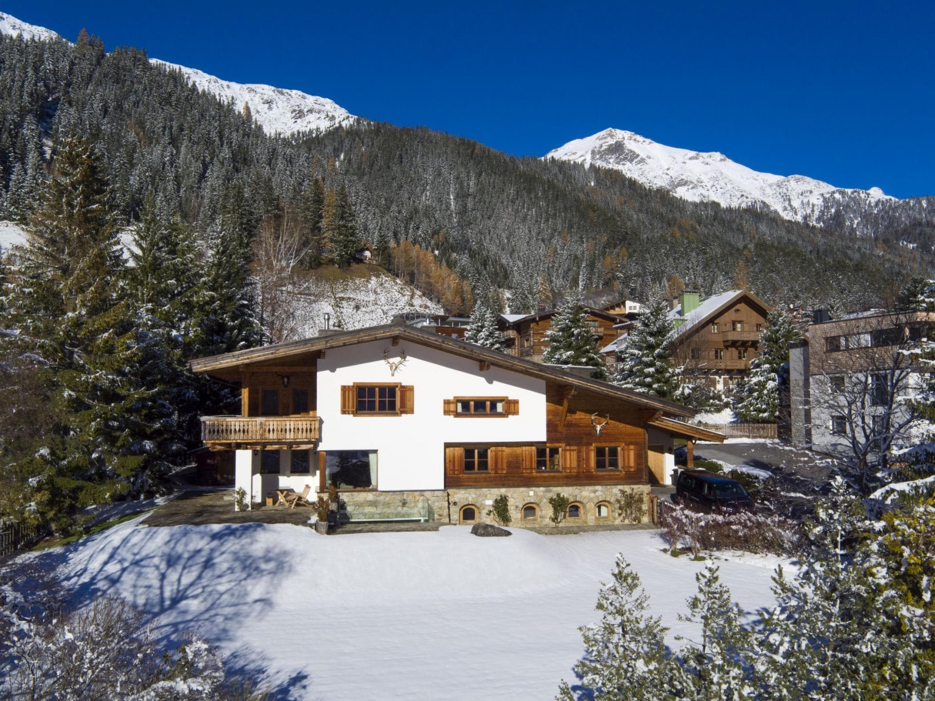 Chalet exterior with private terrace and mountain views; driveway parking included