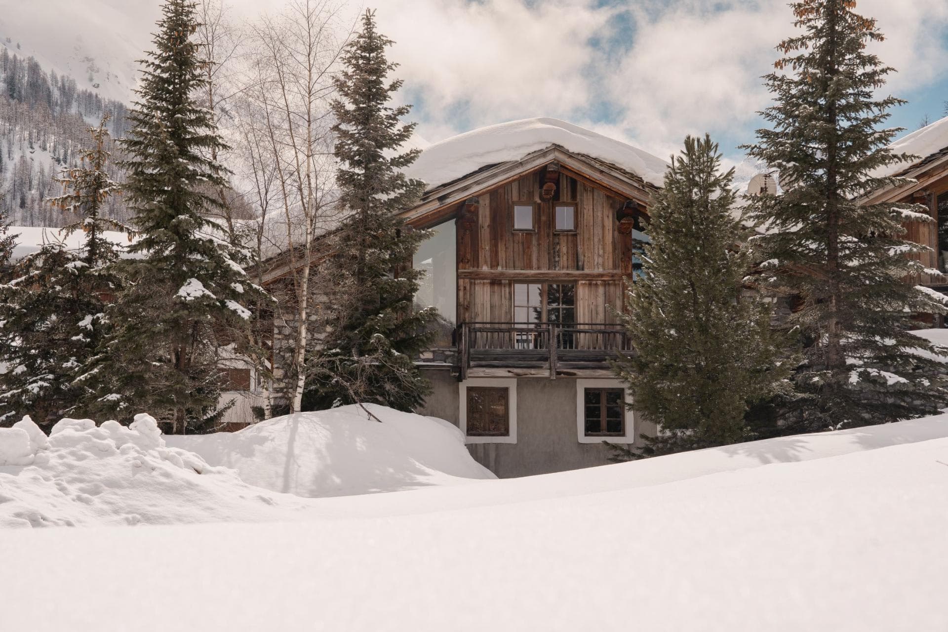 Ski-in chalet exterior with private balcony and timber facade