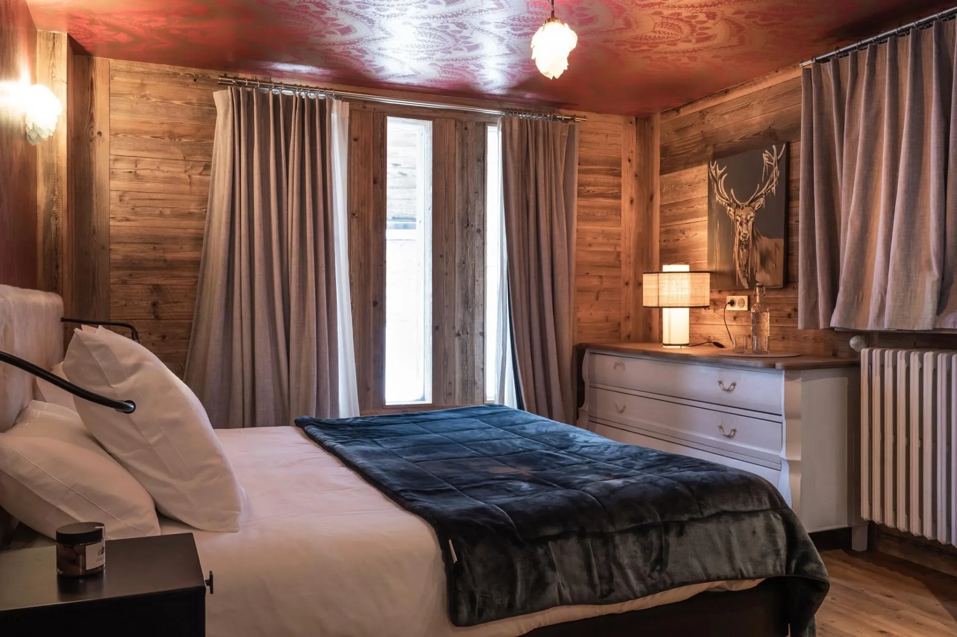 Double bedroom with timber walls and terrace doors