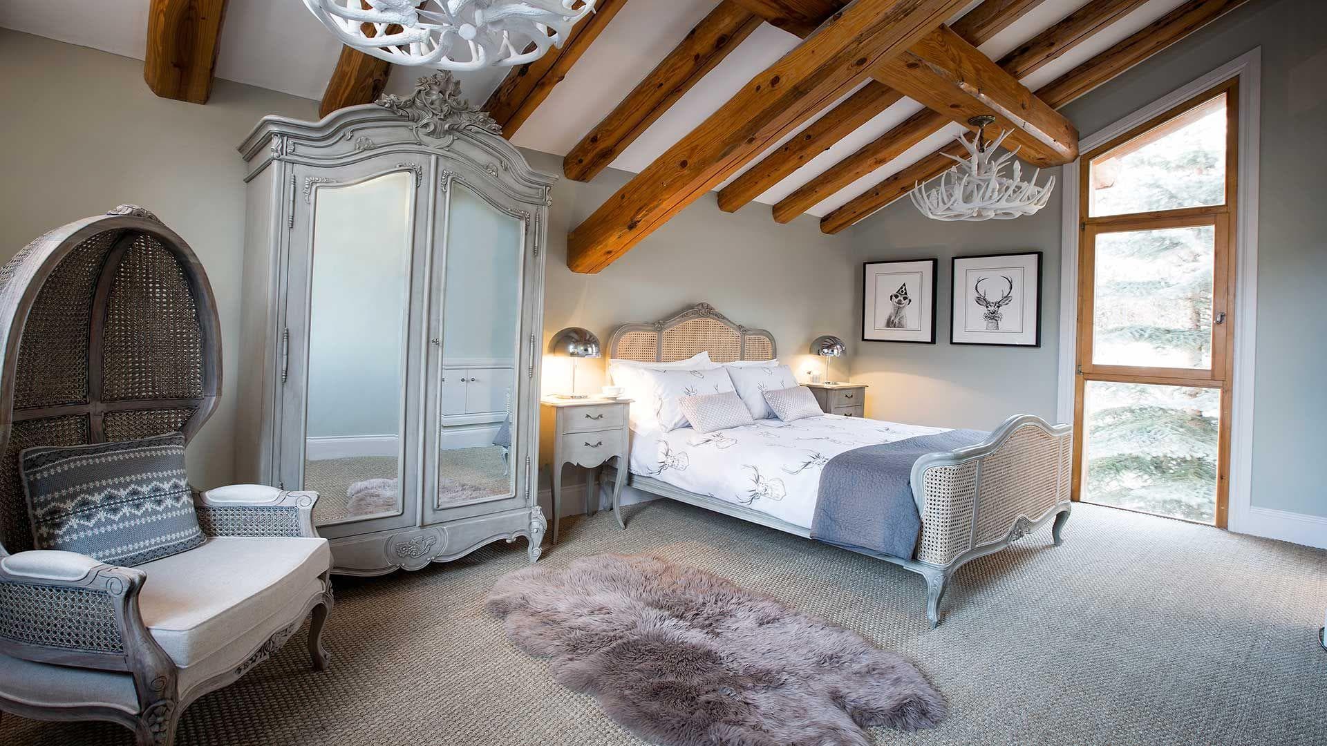 Guest bedroom with queen bed, mirrored armoire, and exposed timber beams