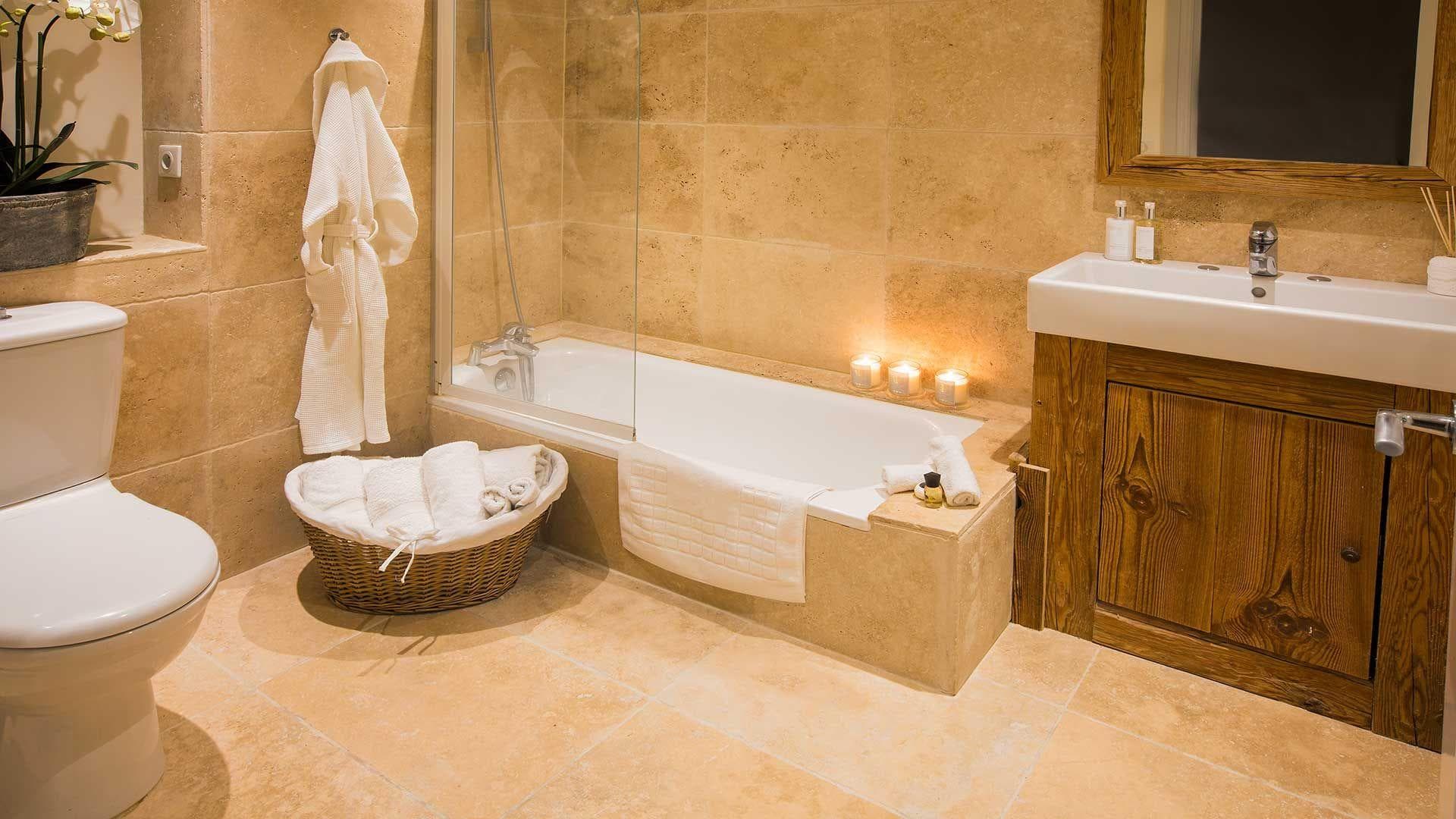 Bathroom with travertine tile and soaking tub with shower wand