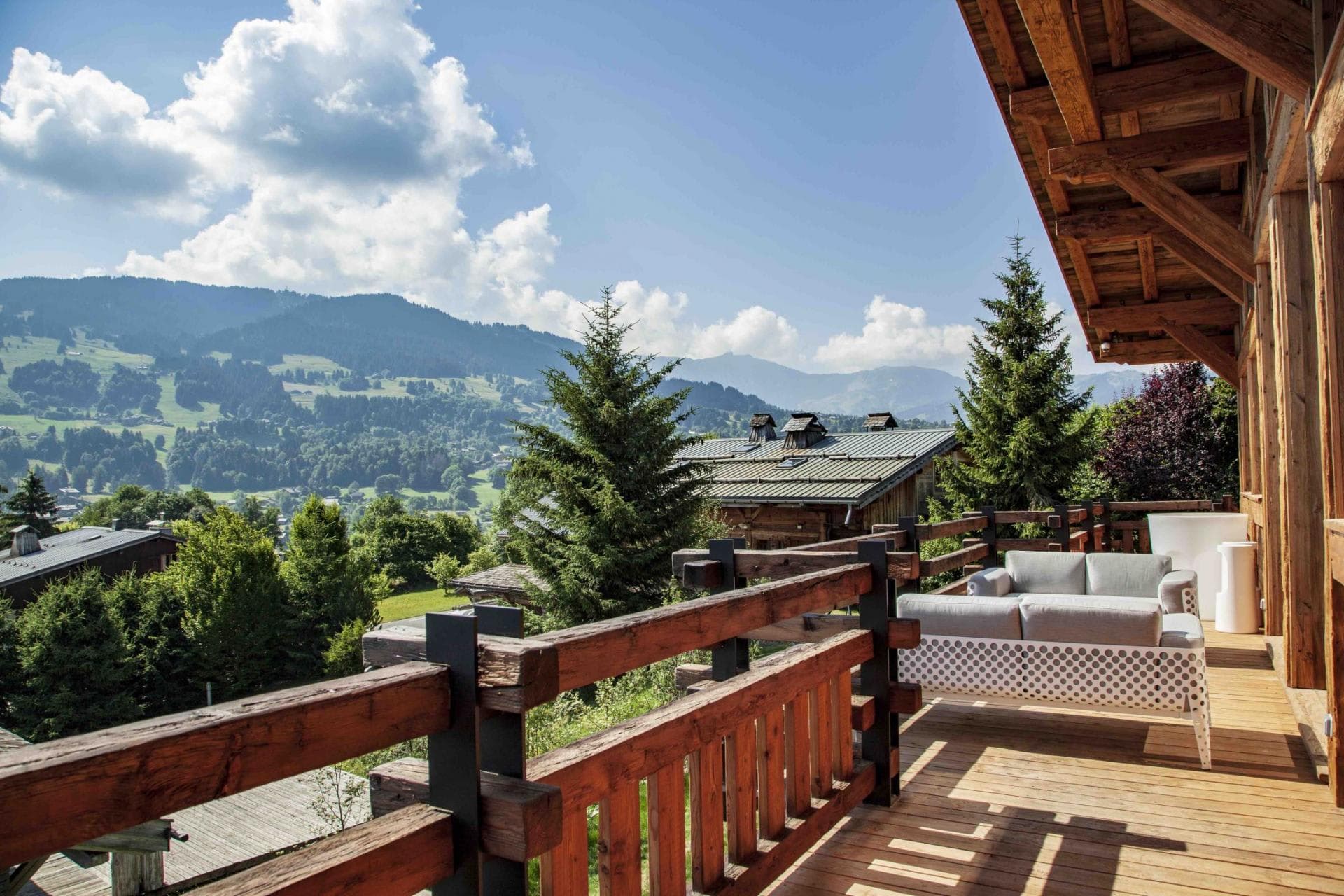 Timber balcony with lounge seating and panoramic alpine valley views