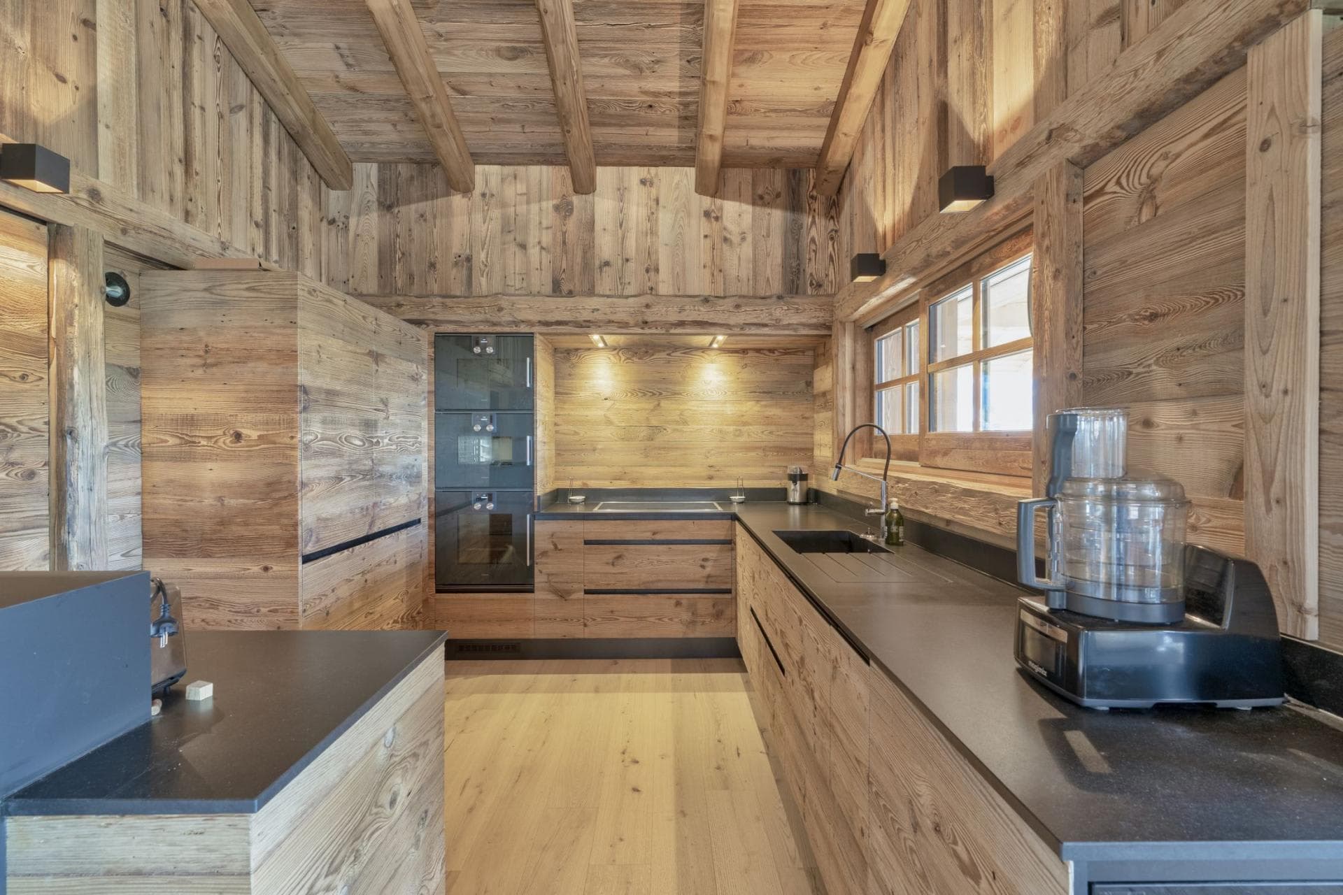 Kitchen featuring integrated appliances and reclaimed wood cabinetry