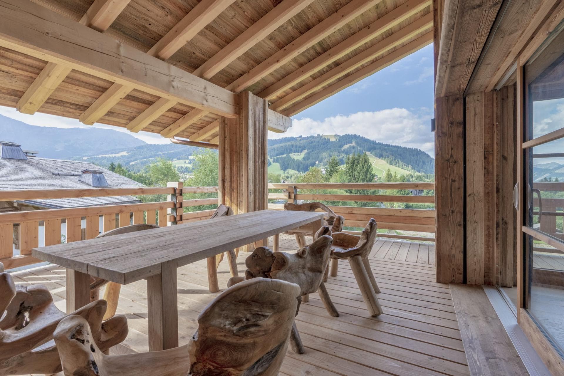 Covered balcony with carved wood seating and alpine valley views