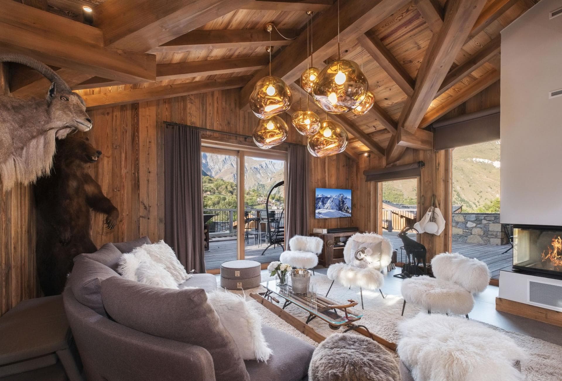 Living area with wood-burning fireplace and deck access to mountain views