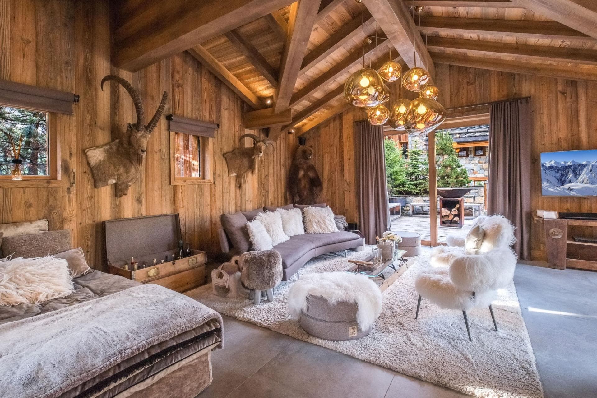Living area with vaulted timber ceilings and access to outdoor fire pit