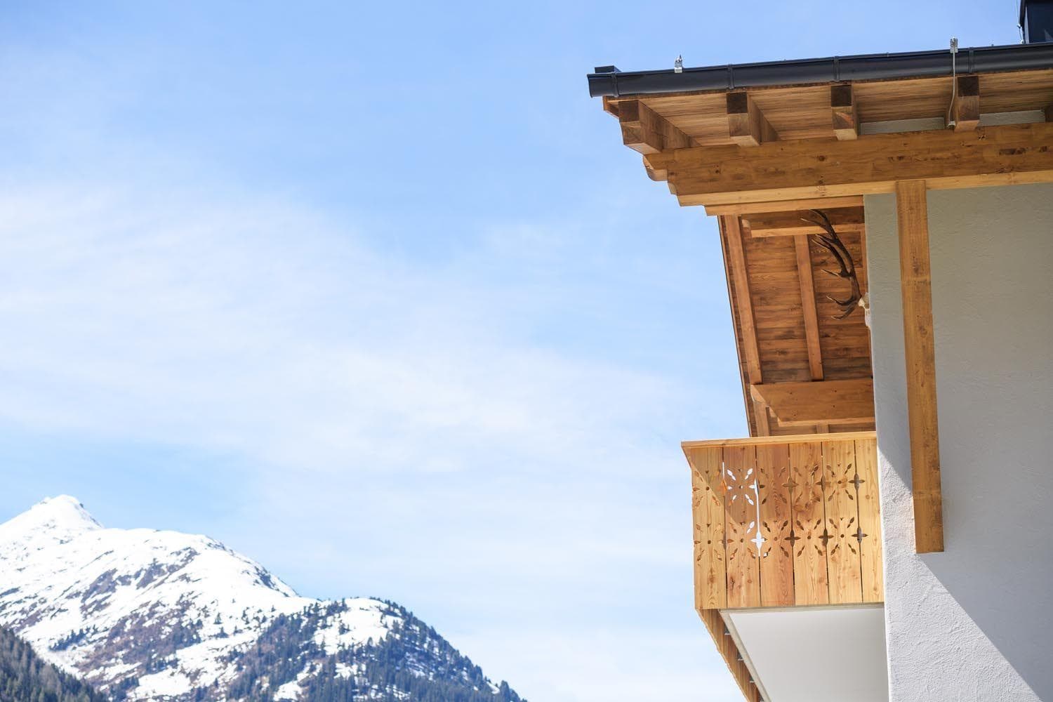 Private balcony with carved woodwork and alpine mountain views