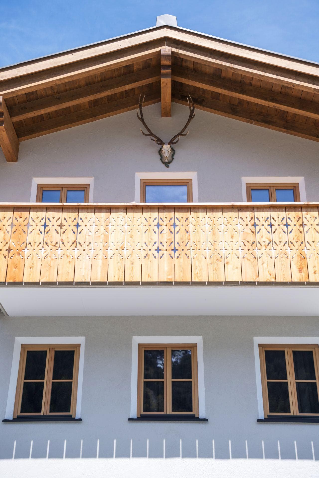 Chalet exterior with carved wooden balcony and traditional decorative antlers