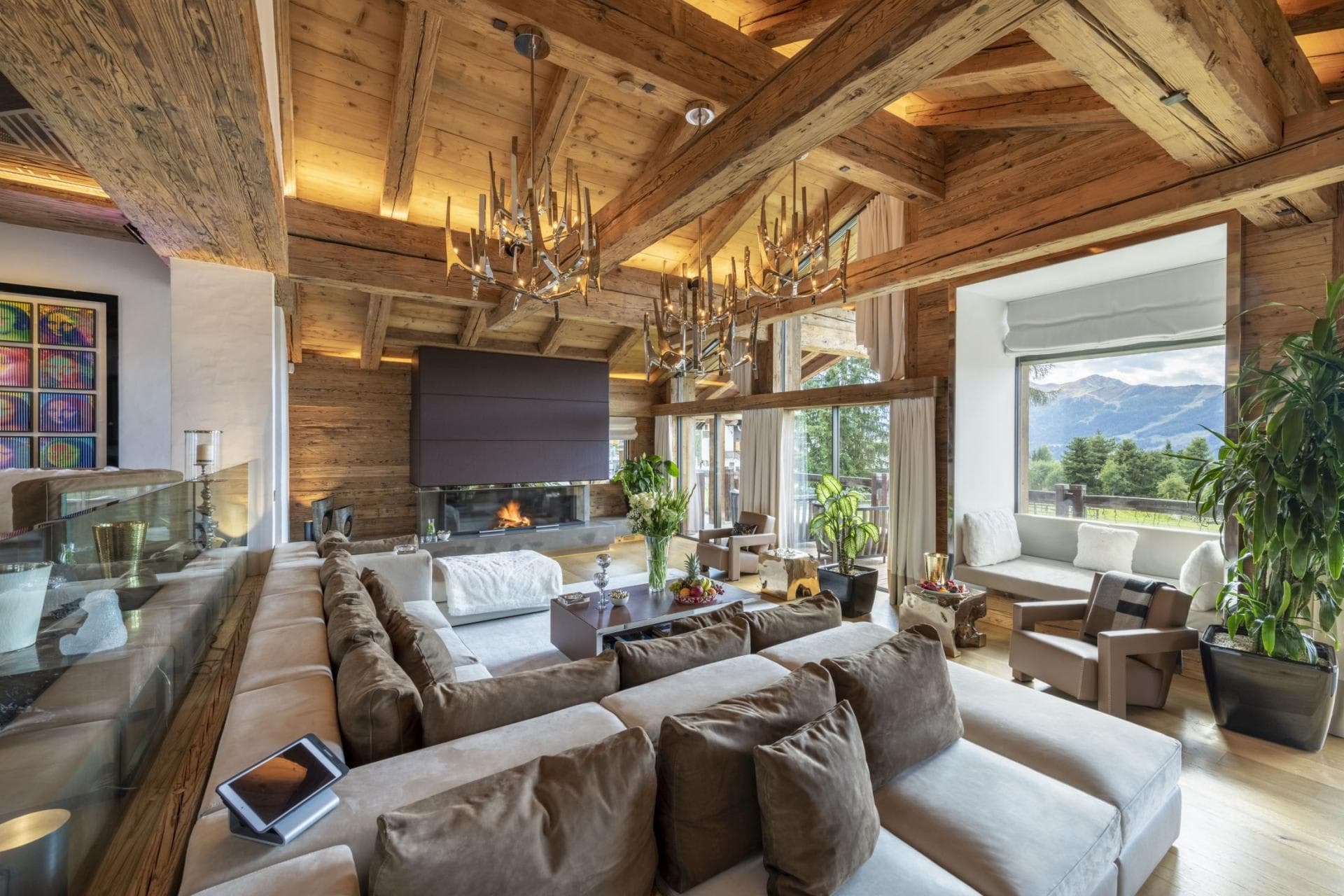 Living area with wood-burning fireplace, vaulted timber ceilings, and mountain-view window seat