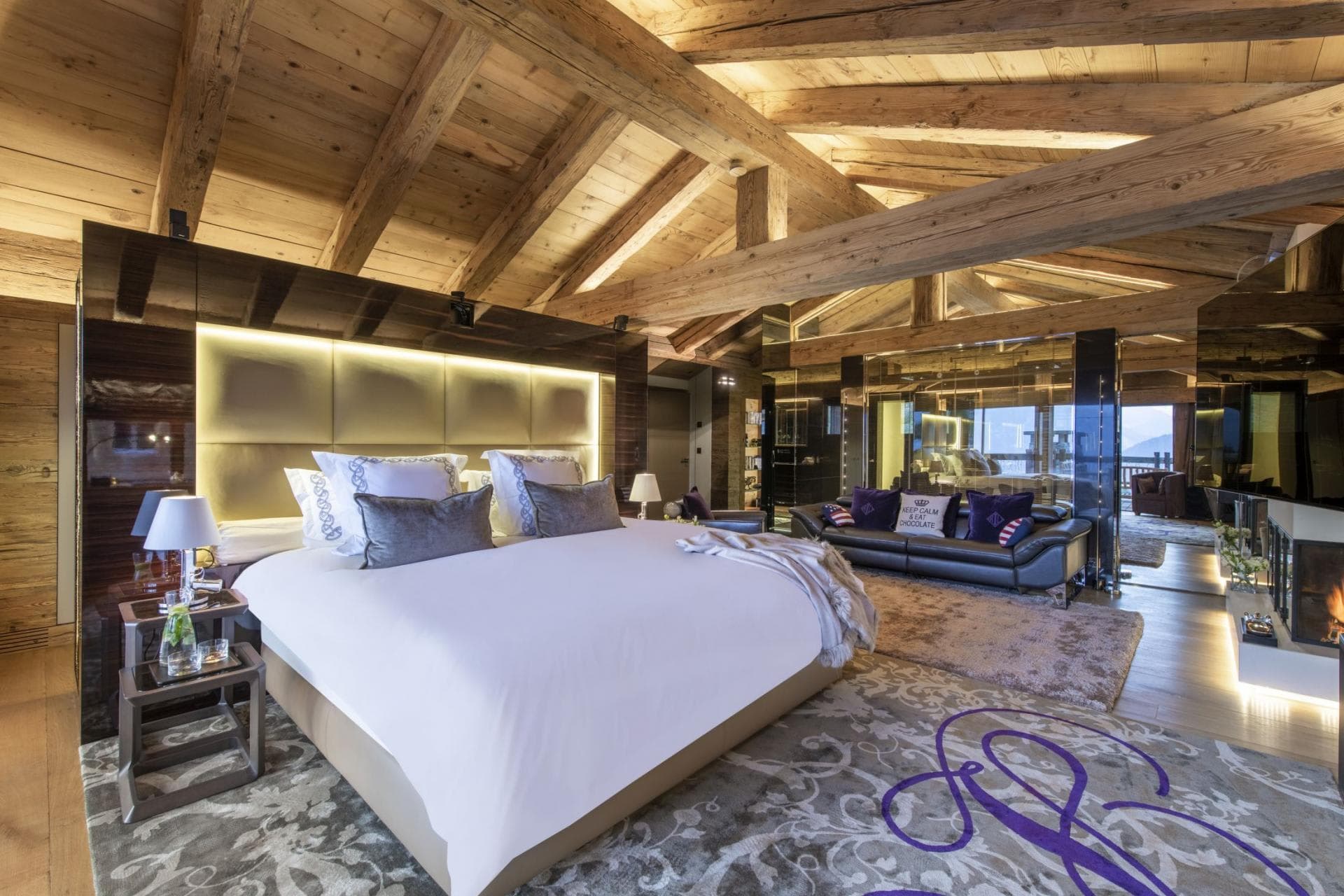 Primary suite with king bed, vaulted timber ceilings, and fireplace