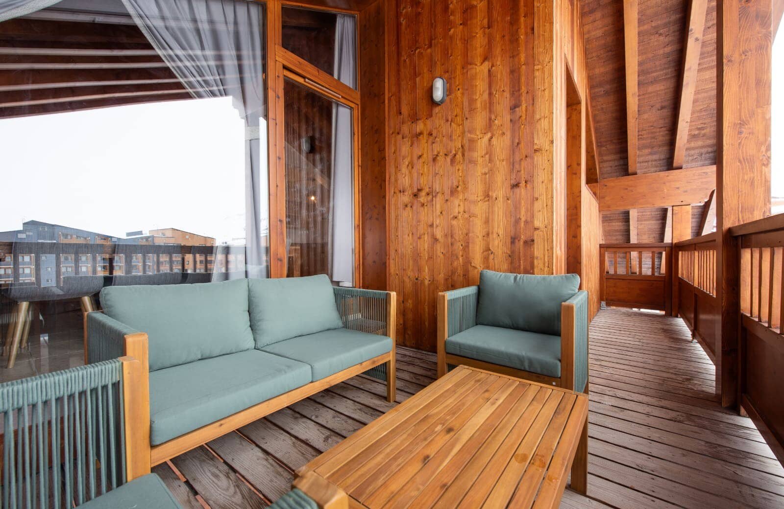 Covered balcony with wood decking and lounge seating for four