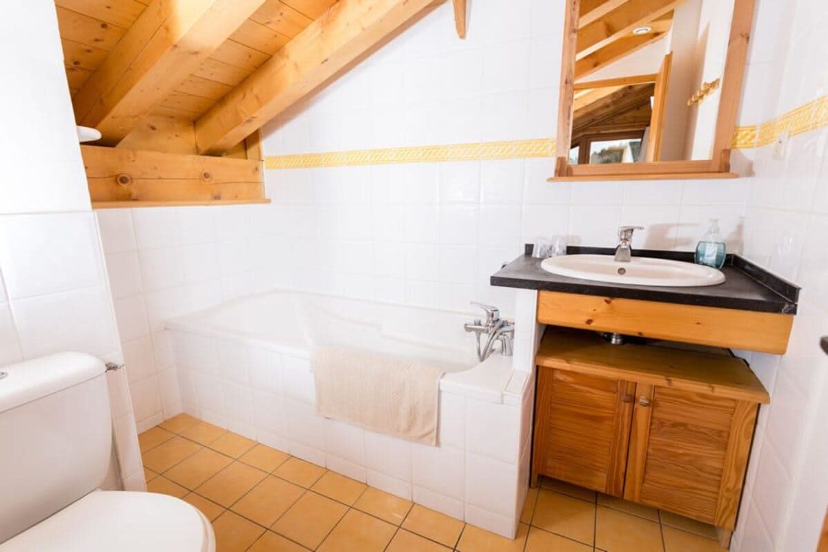 Bathroom with soaking tub and exposed wood ceiling beams