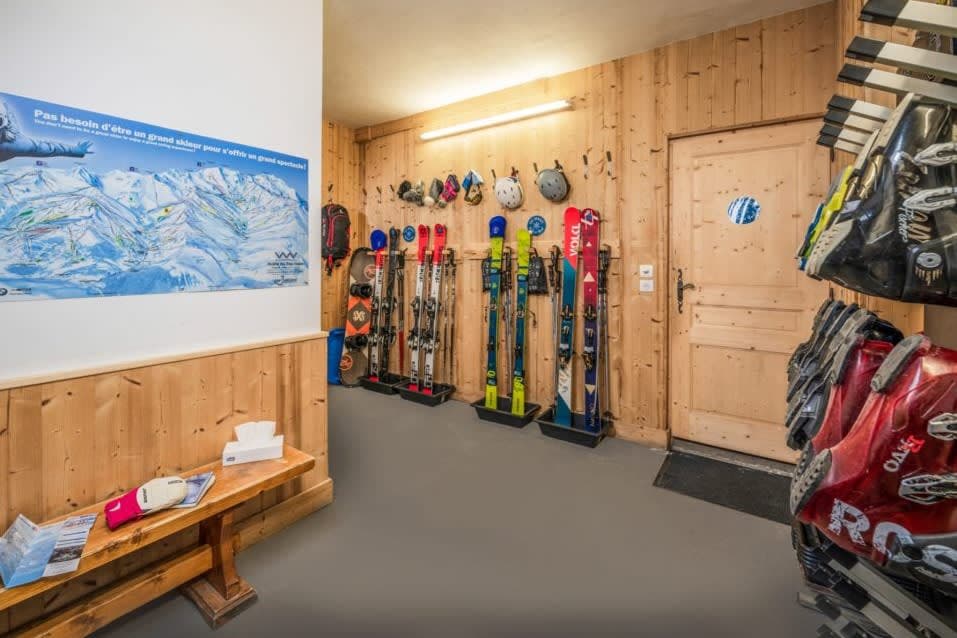 Ski room with heated boot dryers, gear racks, and trail map