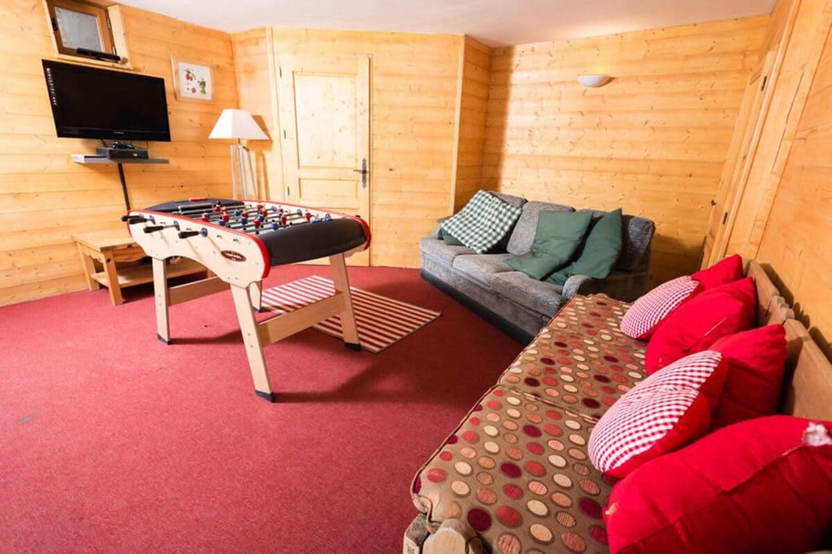 Lower-level game room with foosball table and wall-mounted TV