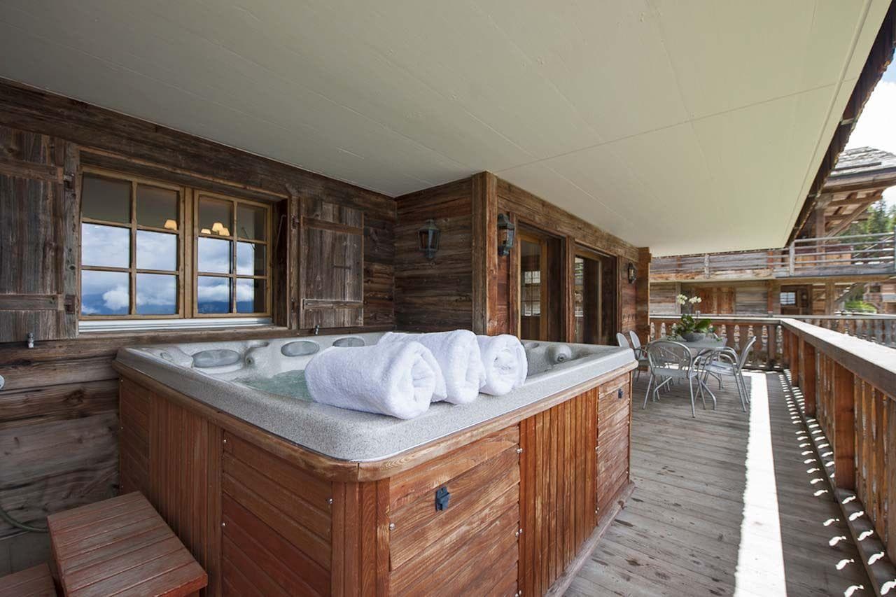 Covered balcony hot tub with mountain views and dining for four